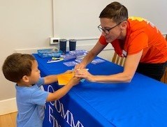 Kristen helps a Plymouth YMCA camper deposit their “Character Cash.